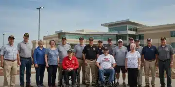 Veterans smiling in front of a modern VA healthcare facility, symbolizing accessible benefits.