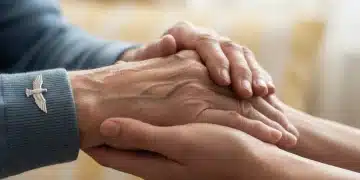 Elderly veteran's hand held by caregiver, symbolizing support for aid and attendance pension.